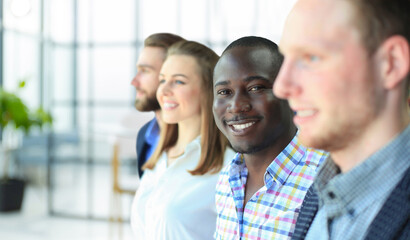 Happy smiling business team standing in a row at office.