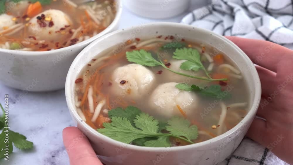 Wall mural potato balls soup with noodles and vegetables in white bowl, white background. vegan food concept.