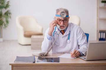 Fototapeta premium Old male doctor otologist working in the clinic