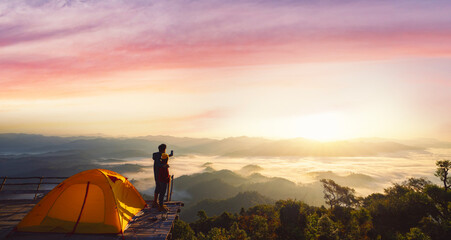 Asian couple enjoy in they tent at they camping point with morning sunrise view © anekoho