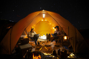 Asian couple enjoy in they tent in camping trip on night time