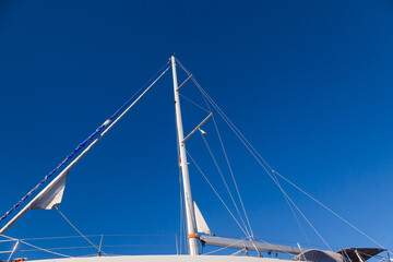 The mast of a sailing yacht, with stretched ropes, without sails.