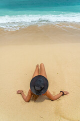 Fototapeta na wymiar Woman with reb swimsuit and black hat at the beach in Bali indonesia