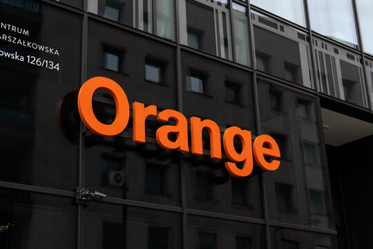 Orange company logo sign. Telecommunications provider signboard with brand logotype at entrance to branch office building on March 24, 2023 in Warsaw, Poland.