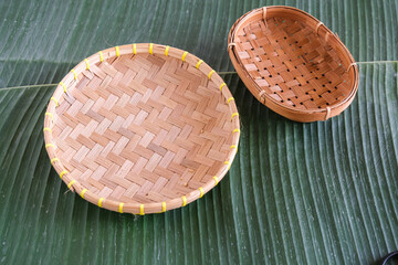 empty bamboo basket on banana leaves
