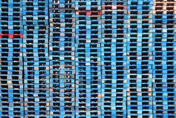 Many colorful blue wooden pallets abstract background stacked stack. Storage and transport equipment pallet concept 