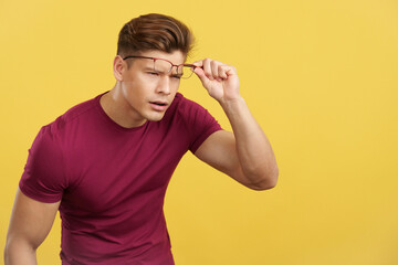 Strong man taking off her glasses to see far away
