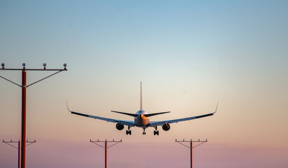 Fototapeta na wymiar Airplane landing during sunset
