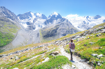 Fototapeta na wymiar A woman alone walks on high mountain trail