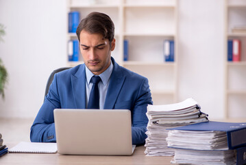 Young male employee and too much work in the office