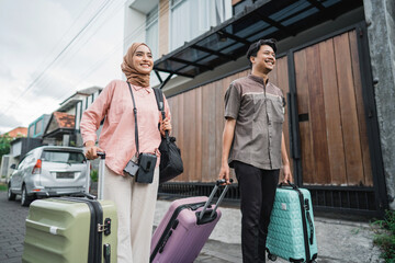 Fototapeta na wymiar asian muslim couple with suitcase prepare to go. concept of man and woman travelling for eid mubarak celebration
