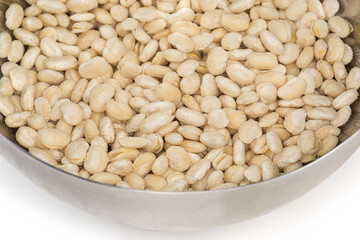 White kidney beans soaked in metal bowl, fragment close-up