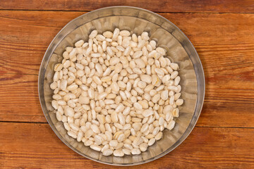 Kidney beans soaked in bowl on rustic table, top view
