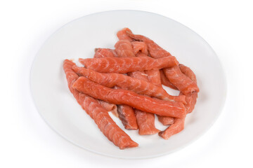 Long slices of uncooked salmon on a white dish