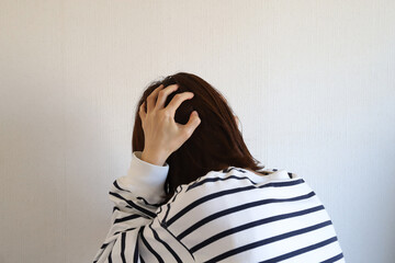 頭を抱える女性　悩みイメージ