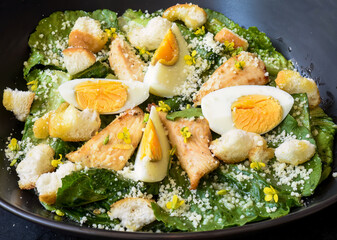 Caesar salad served in Vietnamese style on black background