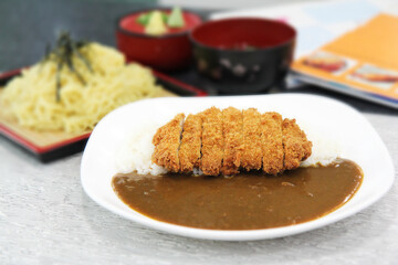 Katsu curry is a Japanese dish consisting of a pork cutlet (tonkatsu) served with a portion of Japanese rice and curry. close-up, selective focus