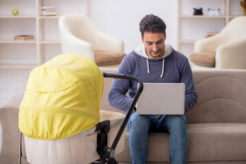 Young man looking after newborn at home