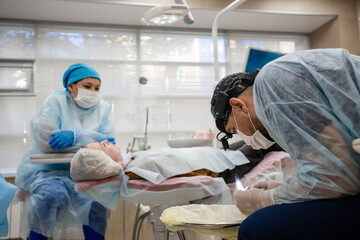 Dentist surgeon prepares a tool for a surgical operation in the clinic