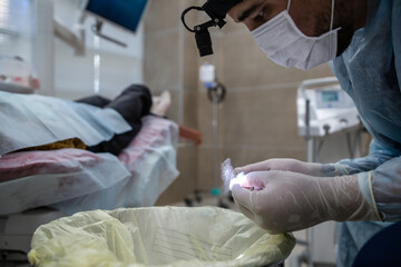 Dentist surgeon prepares a tool for a surgical operation