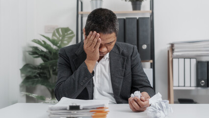 Fototapeta premium Tired, Elderly Old Senior Asian male businessman wearing formal suit ,confident professional bookkeeper doing bookkeeping, lawyer, stock market trader or broker.