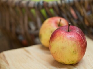 Closeup shot of two red and yellowish apples placed on a wooden table