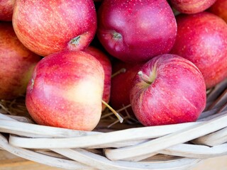 Closeup shot of a pile of tasty fresh red apples placed in a basket