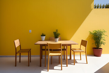 table, chairs and plant in front of a yellow wall in a courtyard in Tavira, algarve, portugal