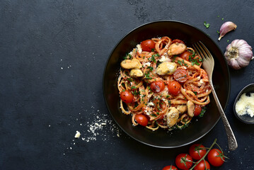 Pasta with mussels and grilled tomato in spicy sauce. Top view with copy space.
