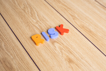 Colorful cubes lettering word "RISK" on wooden background. 