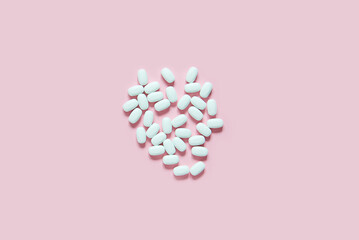 Obraz na płótnie Canvas Medicine pills on a pink. Close up of white large pills with pharmacy and medical concept. Flat lay, top view. 