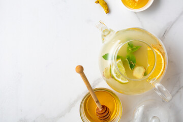 Orange ginger tea in glass teapot  food roots turmeric fruits honey