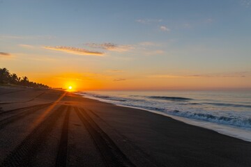 Golden sunrise on a black sand beach in Guatemala