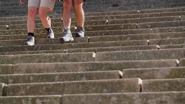 Slow-motion of two senior wearing hiking shoes and going down the stairs