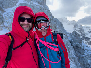 Fototapeta na wymiar Man hike to the peak of the Bavarian Alpspitze during a stormy winter day