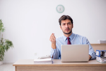 Young male employee unhappy with excessive work in the office