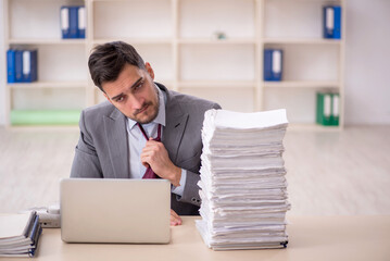 Young male employee unhappy with excessive work in the office