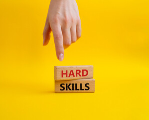 Hard skills symbol. Wooden blocks with words Hard skills. Beautiful yellow background. Businessman hand. Business and Hard skills concept. Copy space.