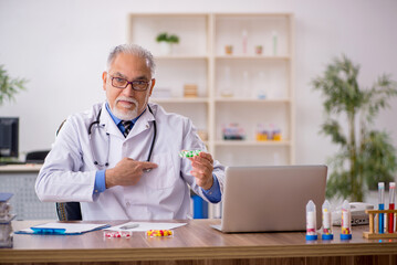 Old male doctor pharmacist in drugs synthesis concept