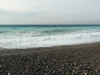 Pebble beach of Nice, France with azure waves of mediterranean sea