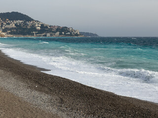 Pebble beach of Nice, France with azure waves of mediterranean sea