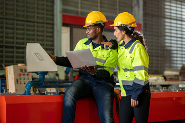 Factory apprenticeship. Man mentor teaching Female employees trainee operating machine looking...