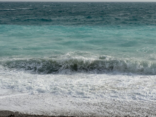 Pebble beach of Nice, France with azure waves of mediterranean sea