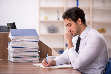 Young male employee and too much work in the office