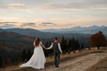 Joyful newlyweds trekking through the Carpathian Mountains