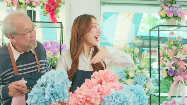 Young beautiful female florist worker with old owner delivering fresh floras to white customer who purchased order, smiling with happy work in colorful flower shop, small business SME entrepreneur.