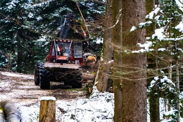 Fototapeta na wymiar Red industrial machine in the forest in winter.
