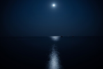 Calm sea illuminated by the moonlight at night
