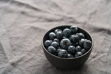 Freshly washed organic blueberries in a black bowl closeup