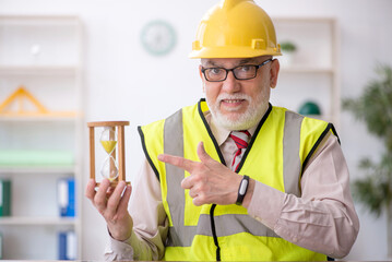 Old male architect in time management concept